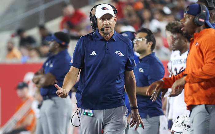 Jeff Traylor walks along the sideline gesturing with his right hand